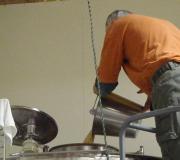 Chuck pitches the yeast into a stainless steel fermentation tank.