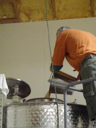 Chuck pitches the yeast into a stainless steel fermentation tank.